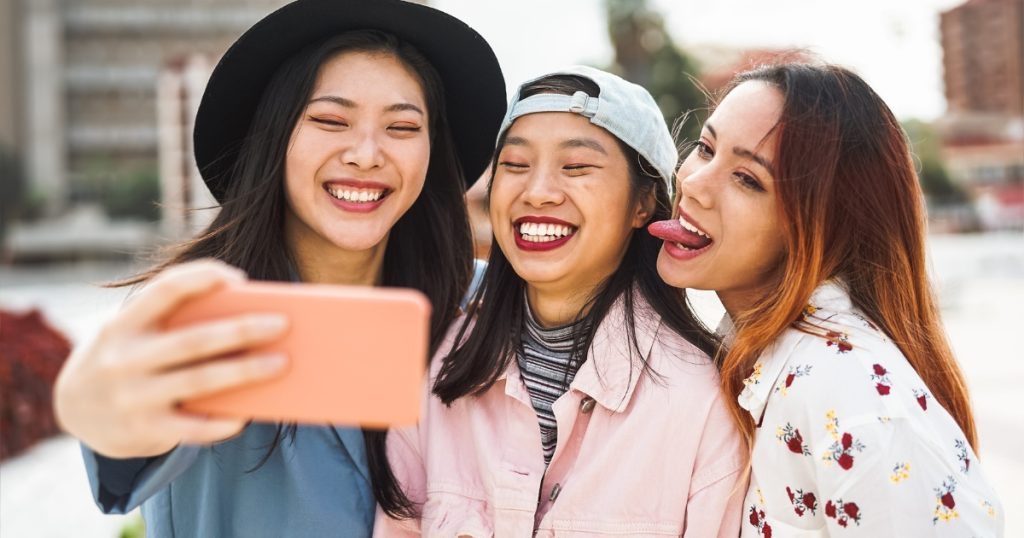 three best friends smiling and laughing while taking a selfie